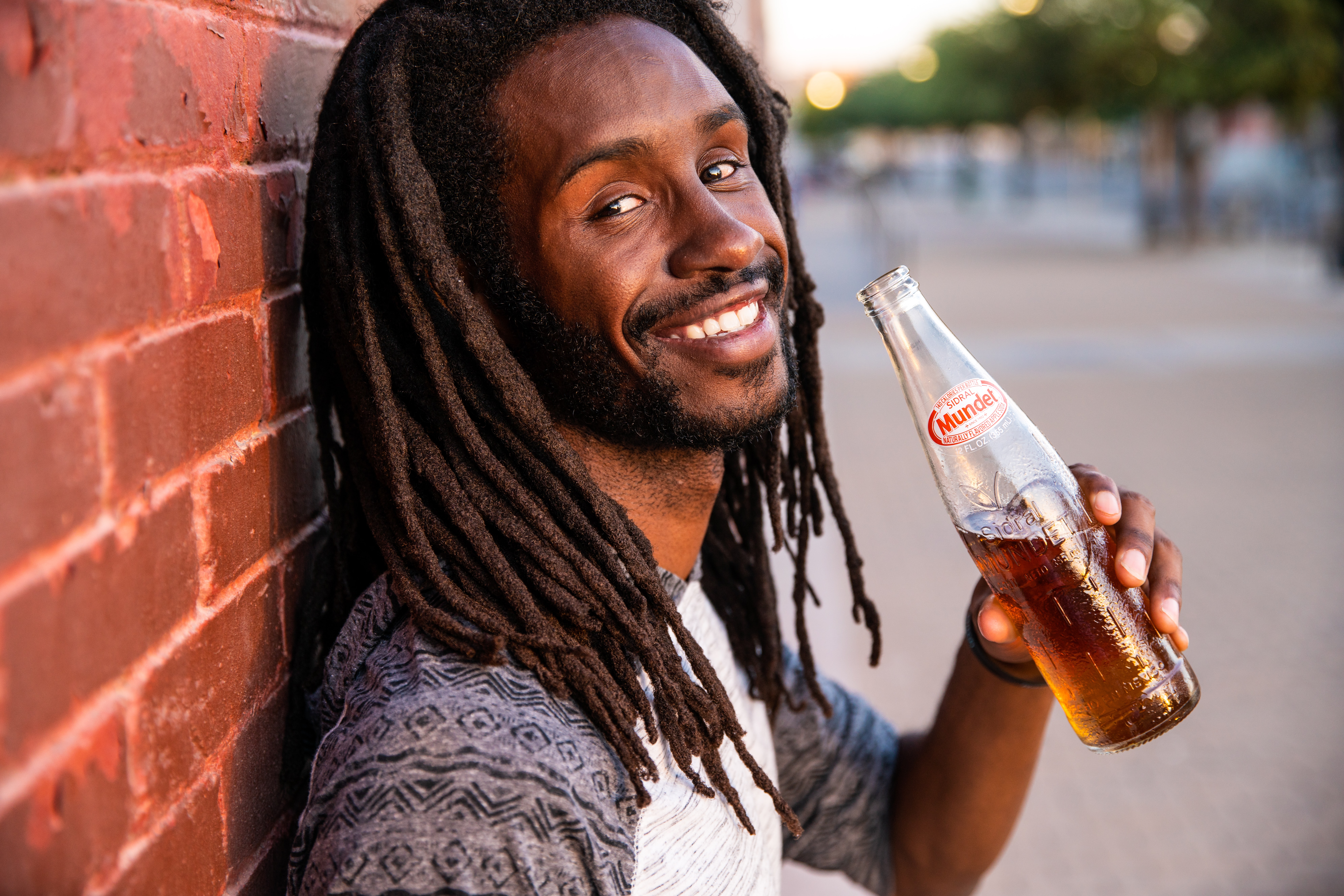 Smiling man sips on low-alcohol beer drink.